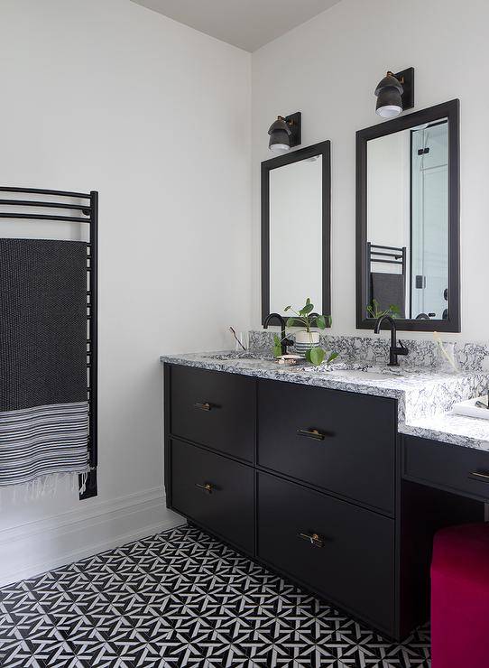 Modern black and white bathroom features a black dual washstand topped with black and white marble and a matte black gooseneck faucet under black framed inset medicine cabinets and black geometric floor tiles.