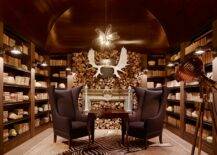 Amazing den with wood barrel ceiling built-in bookcases, stone fireplace, zebra cowhide rug and black linen wingback chairs with silver nailhead trim.