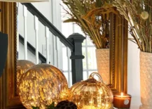 A fall entryway with pumpkins that have lights.