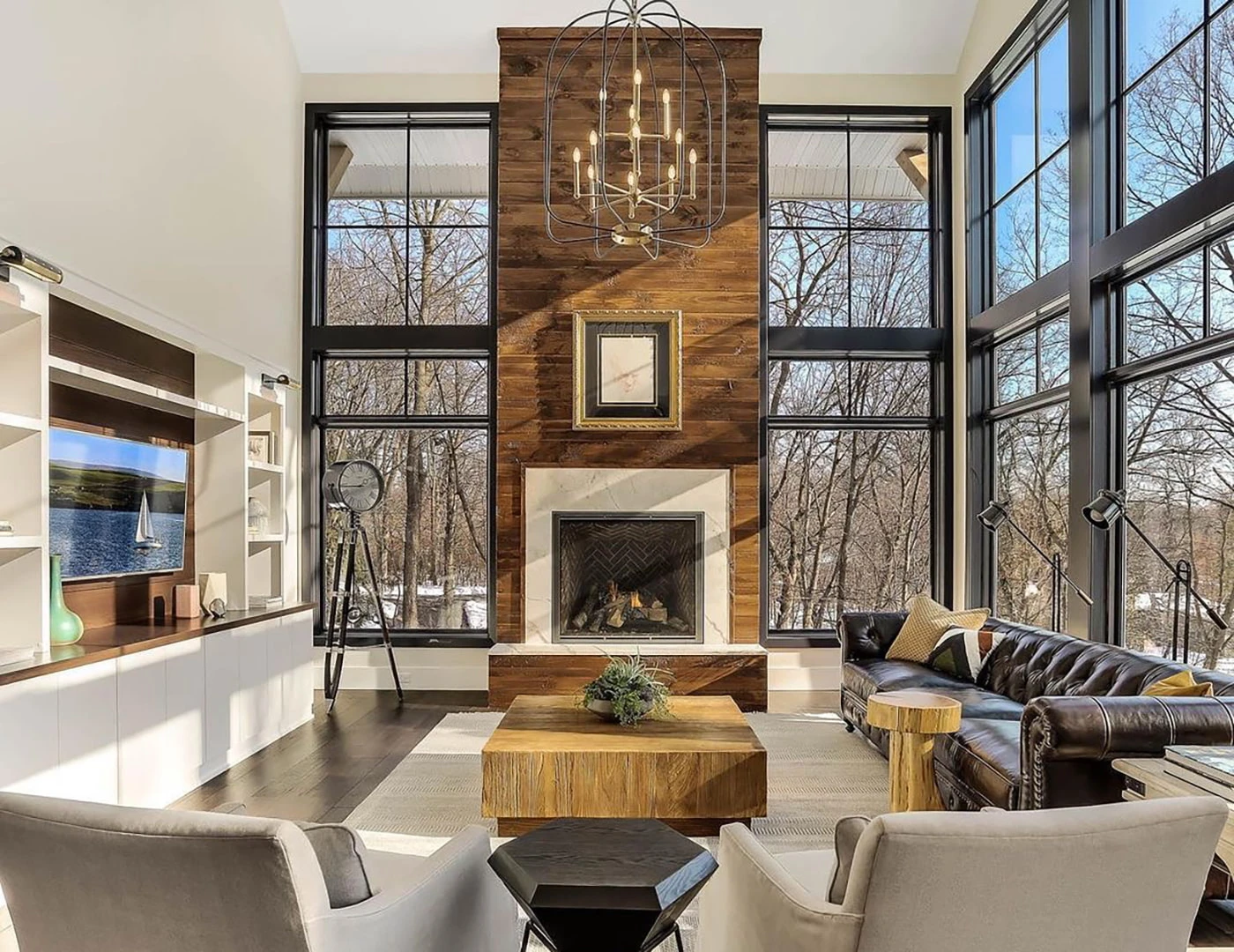 Modern living room with a fireplace flanked by floor-to-ceiling windows.