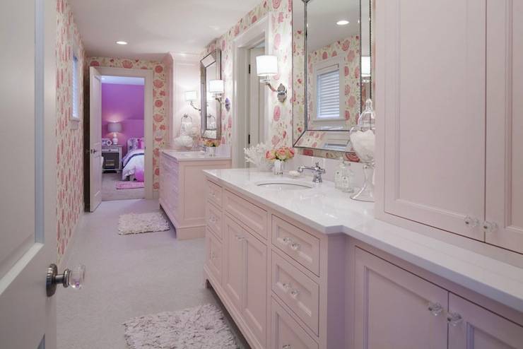 Fun pink girls' bathroom! Whimsical hot pink floral wallpaper and light pink recycled bath mats. Beaded venetian mirror over pink cabinets with crystal hardware and Zeus Quartz countertops
