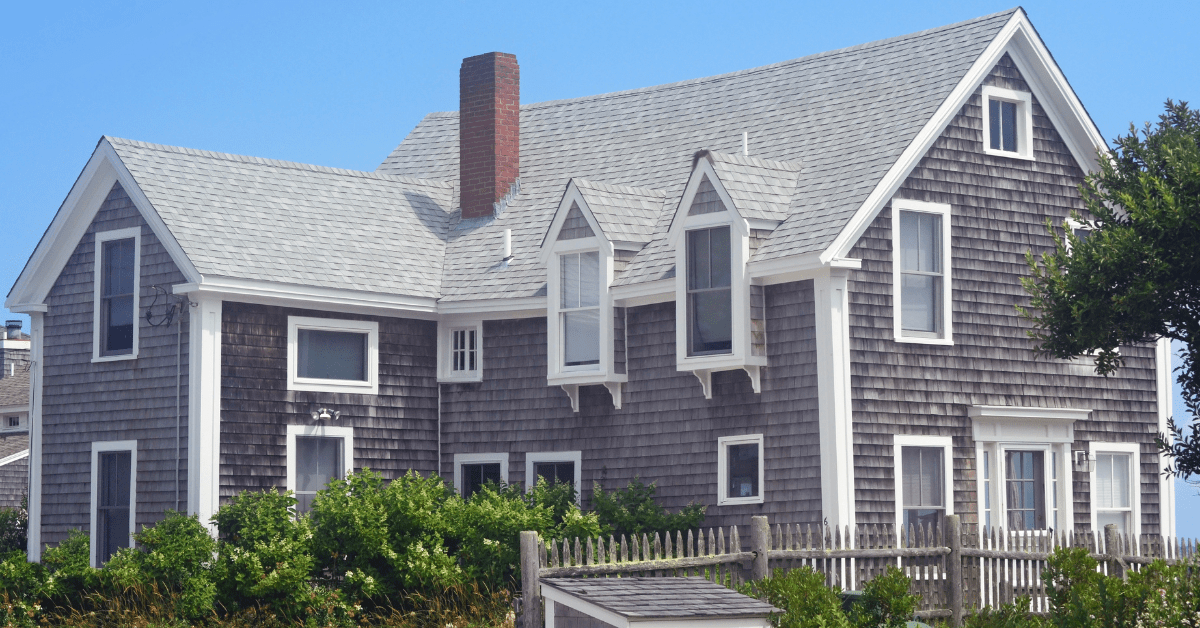 Cape Cod style house with red brick chimney.