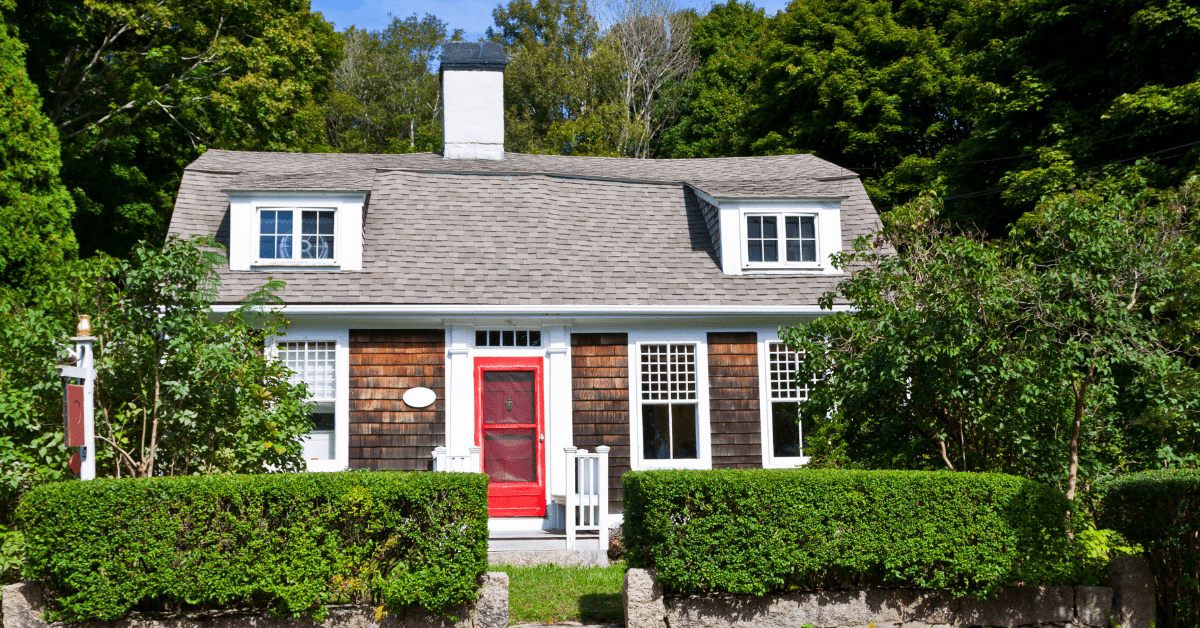 Small Cape Cod style house with red front door.