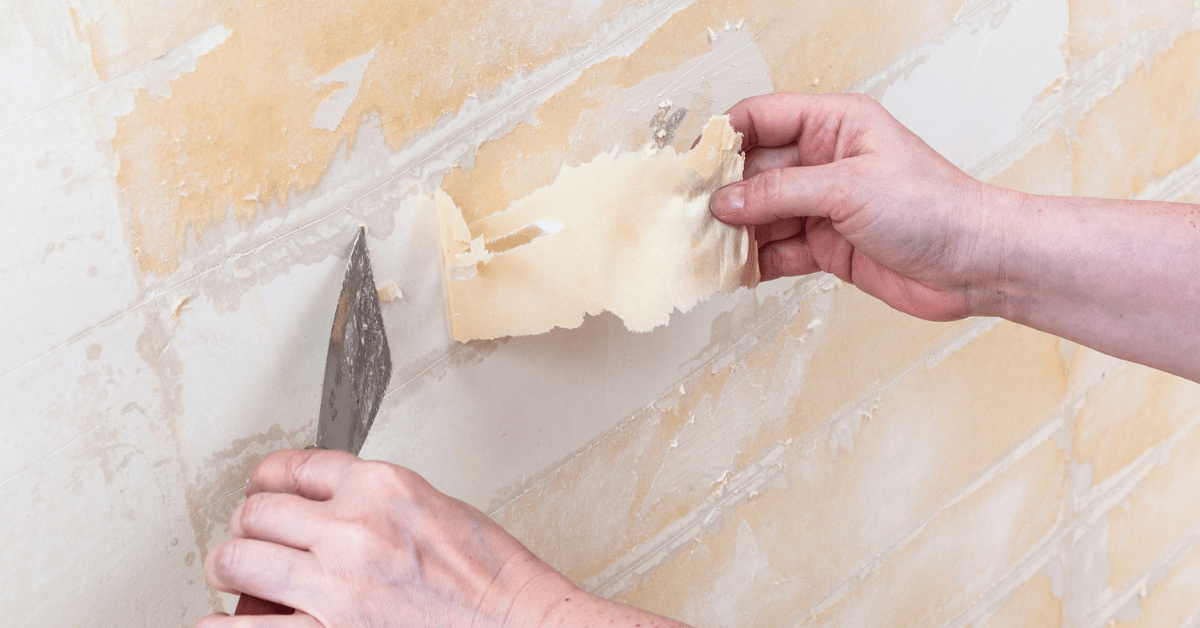 Hand peeling back wallpaper.