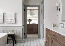 Gray wainscoting accents while walls and floors covered in gray marble hexagon floor tiles.