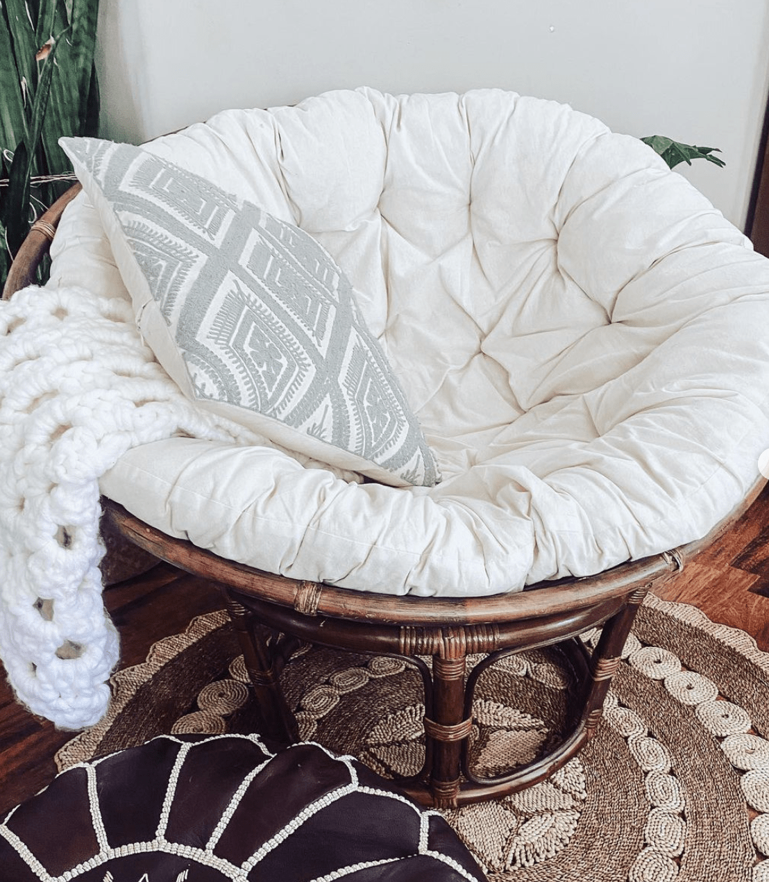 white papasan chair with large cushion and brown wood base