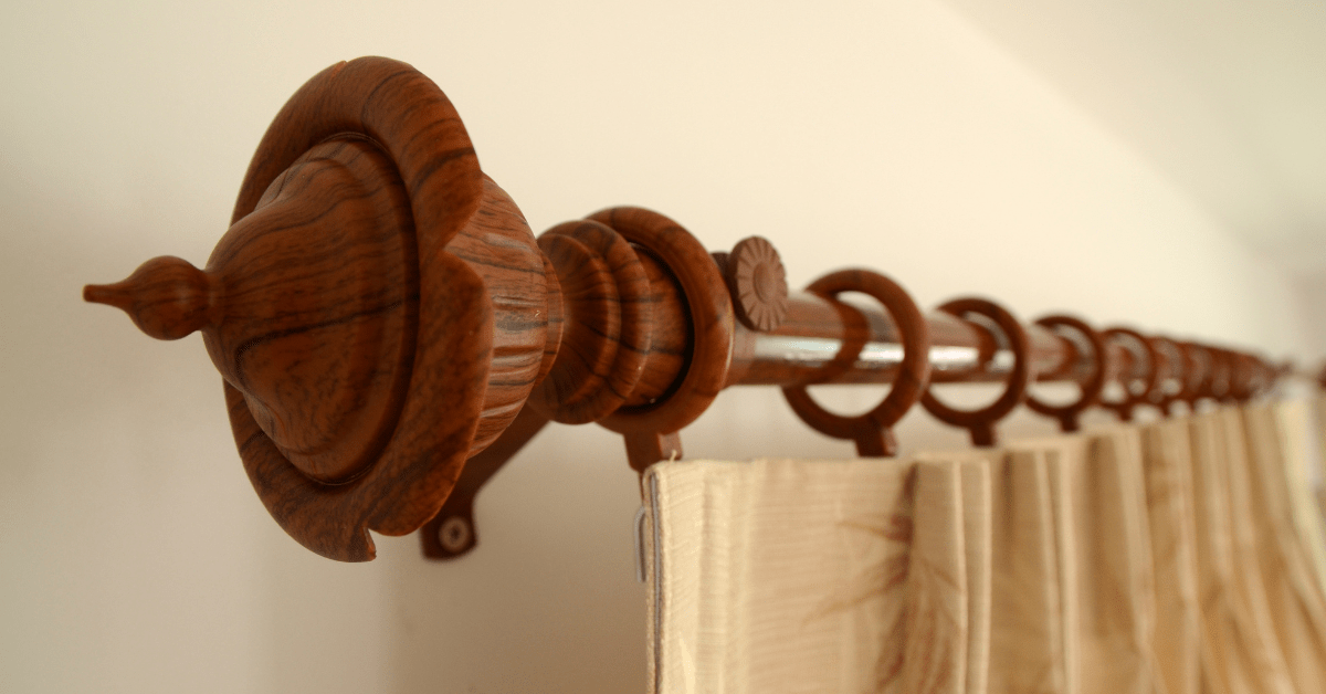 Wood curtain rod with curtains hung on it.