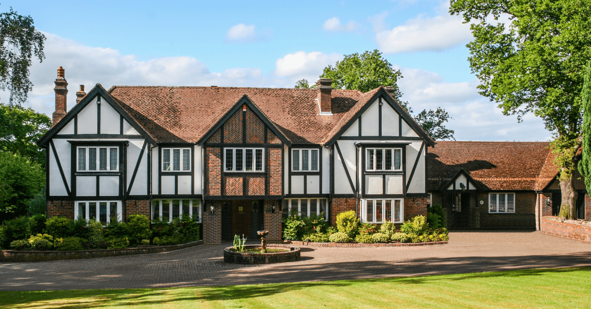 Exterior of Tudor styled house with green landscaping.