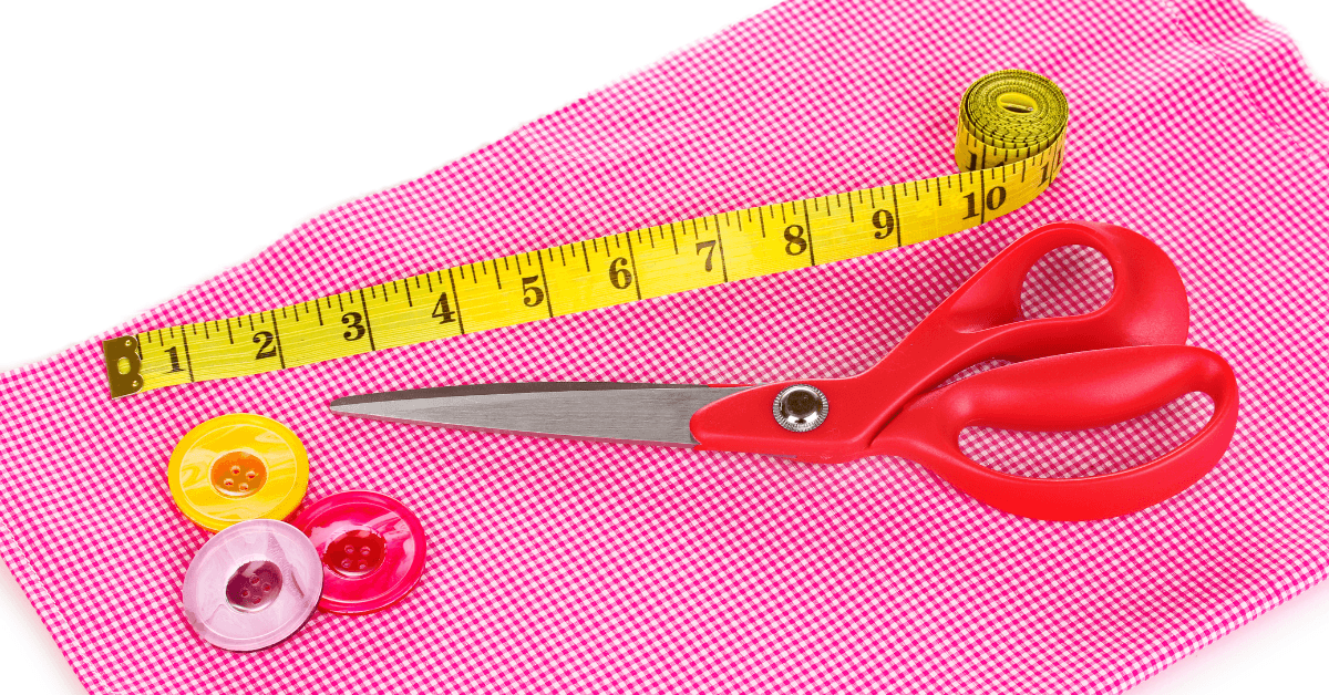 Tape measure and scissors on textured fabric.