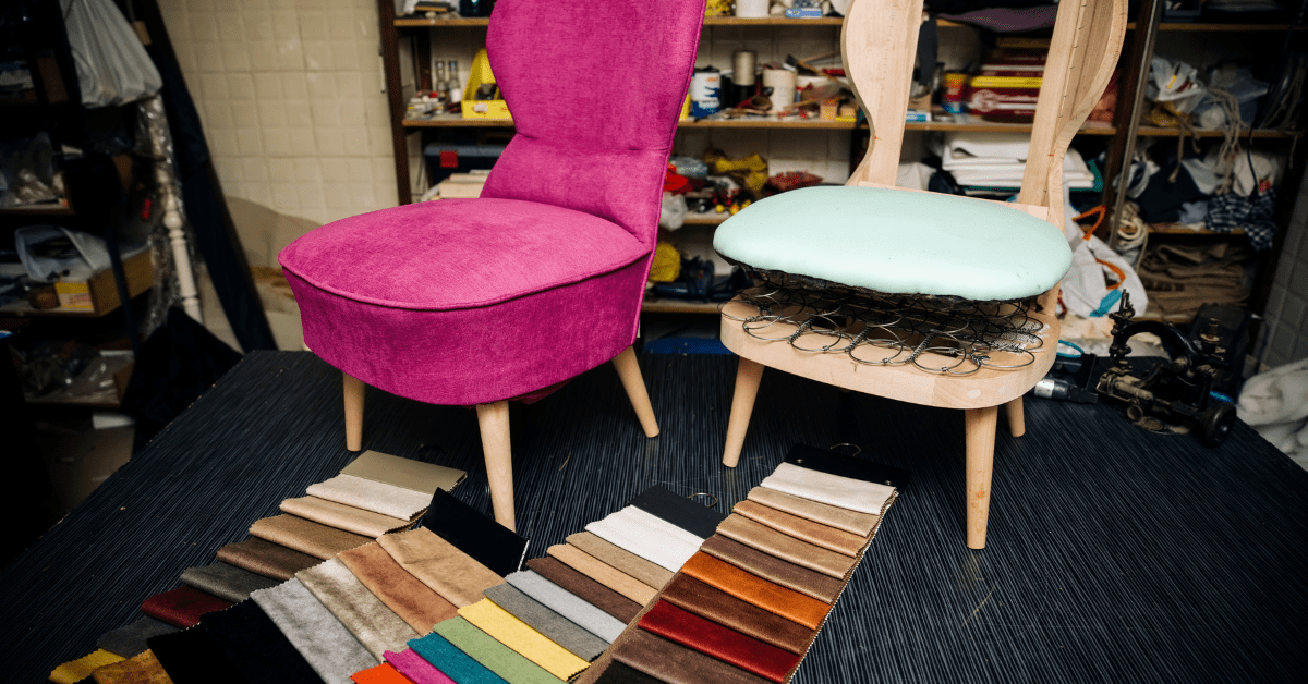 Two chairs, one missing upholstery, fronted by fabric samples.