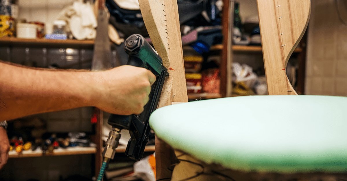 Worker preparing a chair for upholstery.