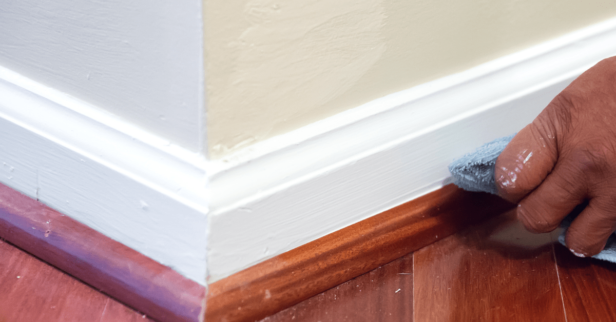 White baseboards being cleaning with microfiber.