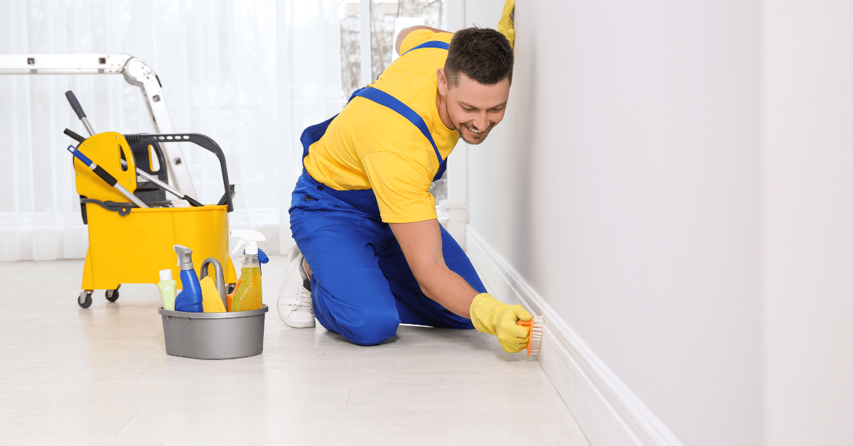 Person using brush to clean baseboards.