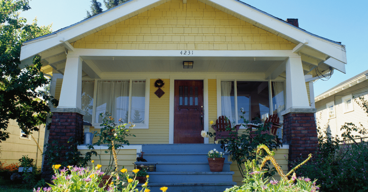 Yellow Bungalow house with stair walkup and garden.