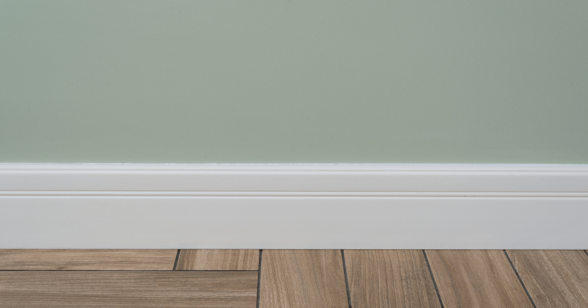 Green painted wall and white clean baseboards.