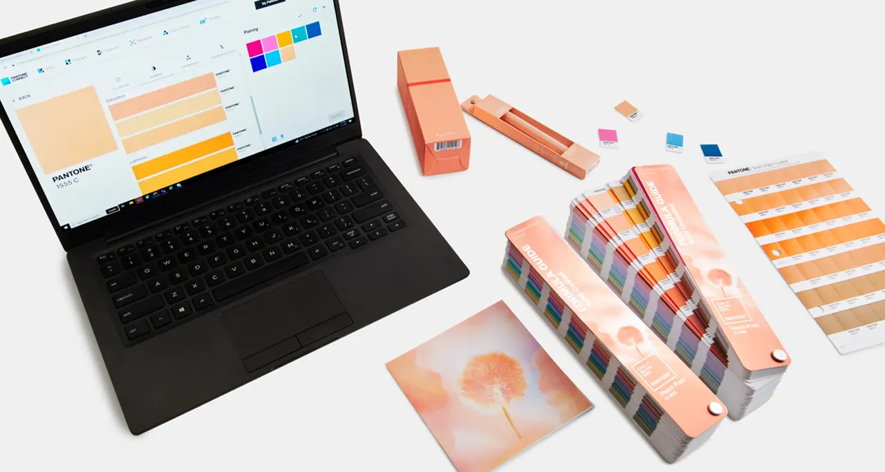 Laptop behind color palettes of Peach Fuzz 13-1023.