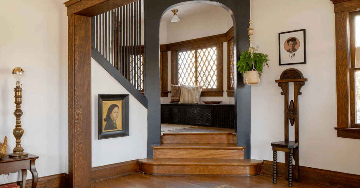 Interior de uma casa de artesão, apresentando detalhes em madeira e escadaria.