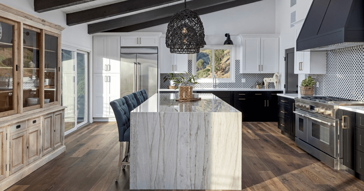 Modern kitchen with marble island and luxury vinyl plank flooring.