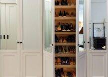 Glam walk-in closet boasts a wall of mirrored shoe cabinets lined with stacked pull-out shelves.