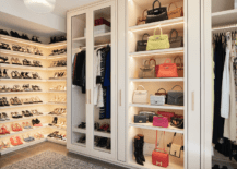 Pink-beige lighted bag shelves are flaked by glass front wardrobe cabinets, while l-shaped shoe cabinets are lighted and mounted in a corner.