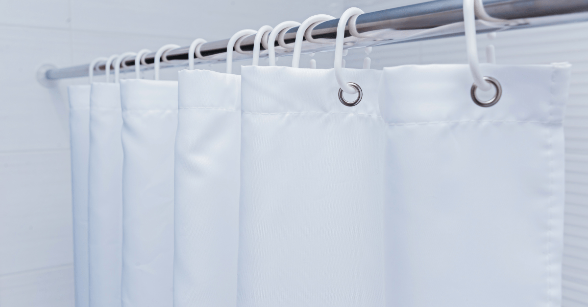 White standard shower curtain size with plastic hooks.