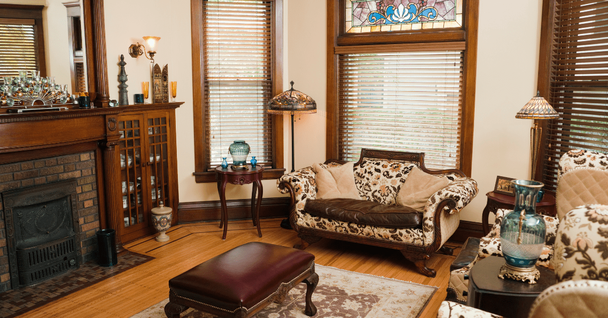 Living room of a Victorian style house with hard wood furniture and velvety upholstery.