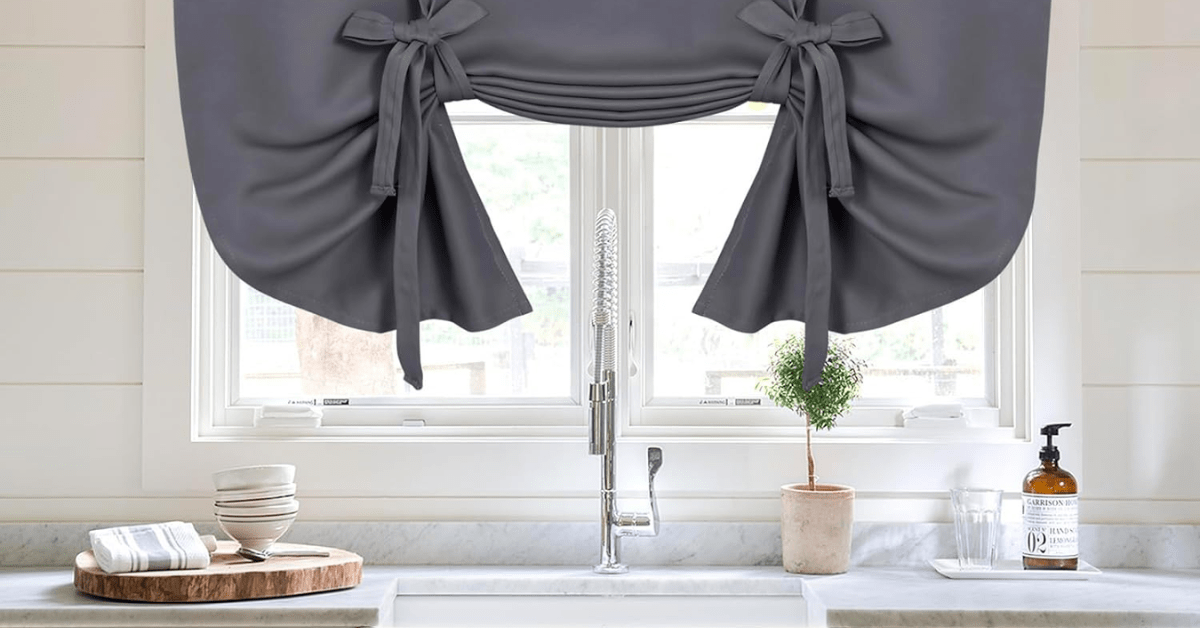 Grey tie-up curtains on kitchen windows.