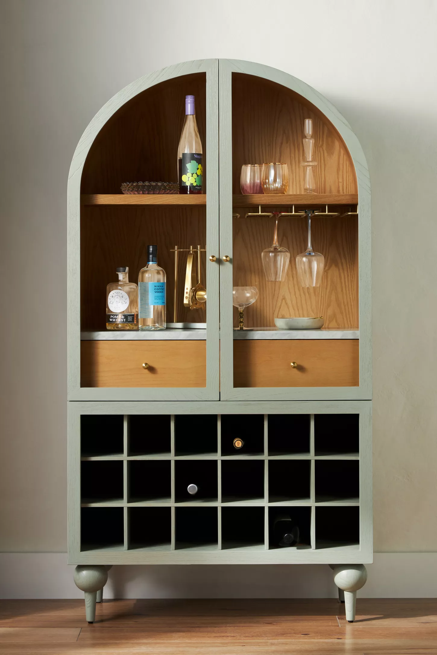 A large bar cabinet finished in sage green.