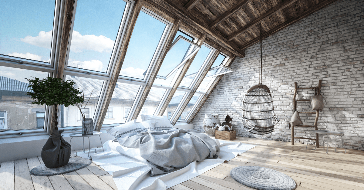 Bedroom of an industrial loft, featuring large windows.