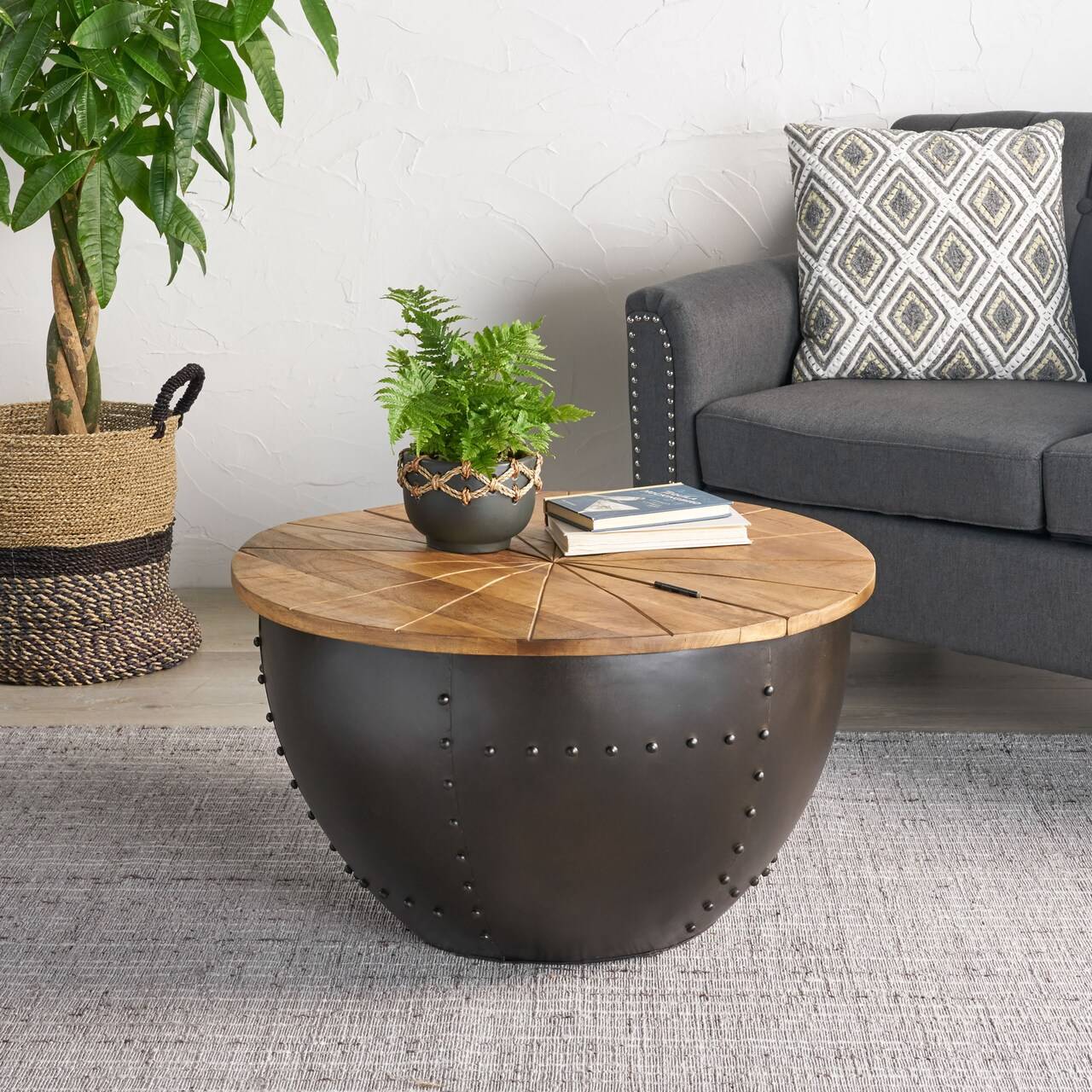 A metal base round coffee table with wooden top in a boho living room.