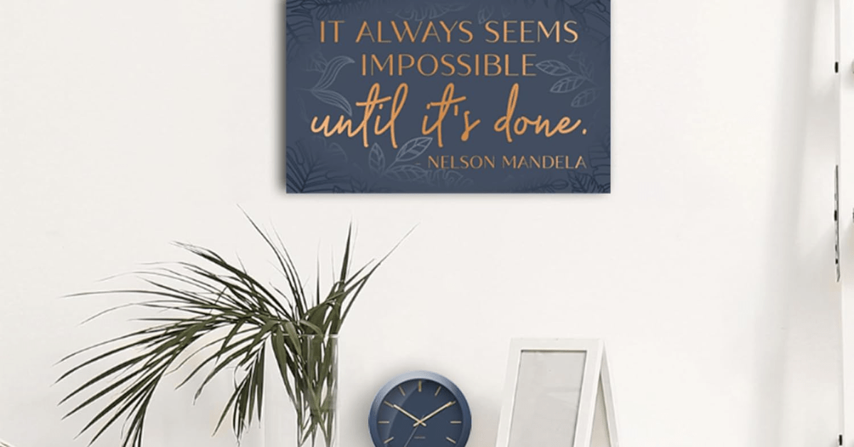 A closeup of a quote hung on an office wall as decor.