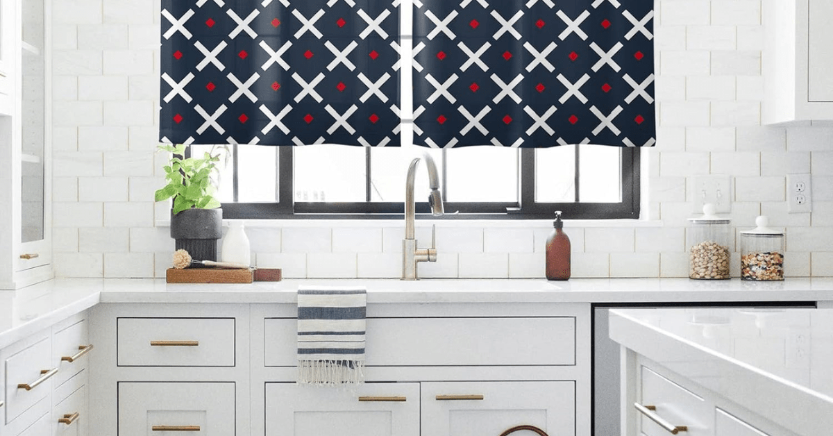 A white kitchen with patterned curtains.