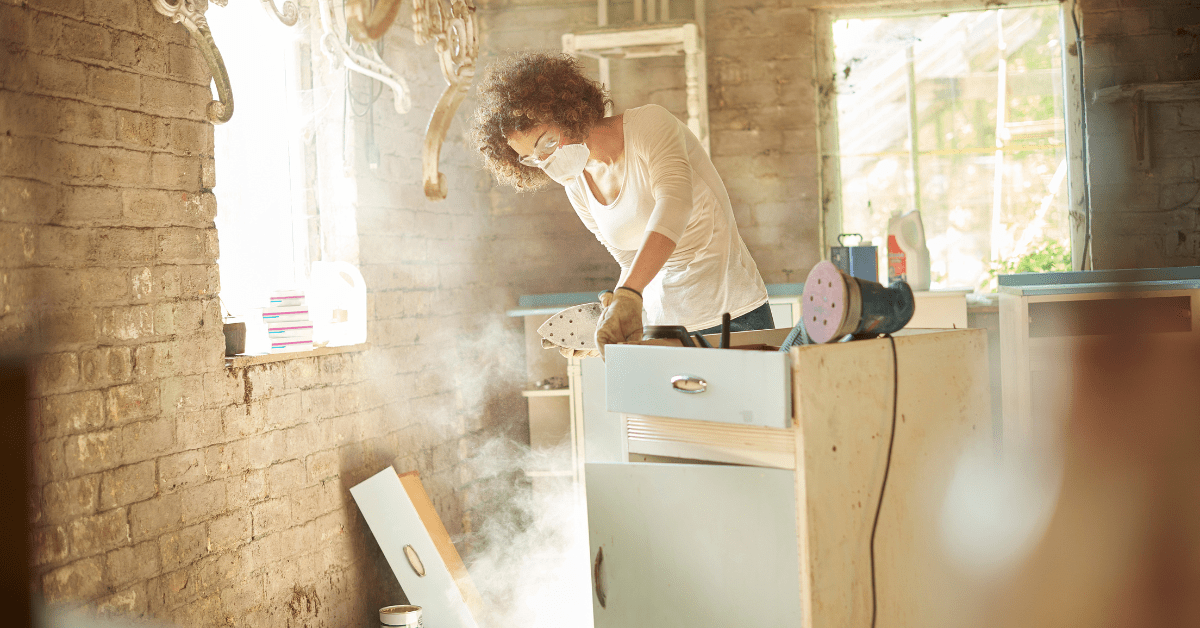 Woman working on a DIY project to upcycle her old kitchen.