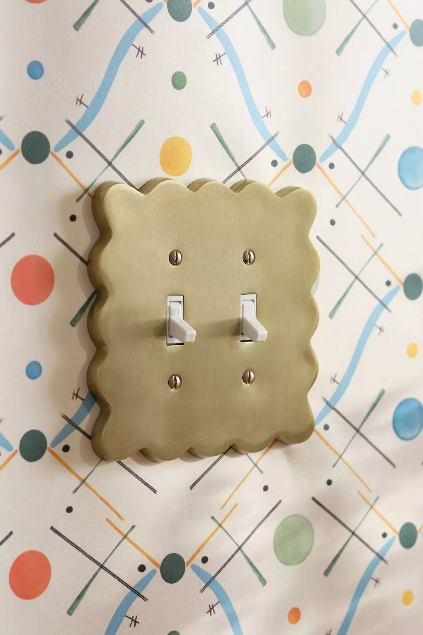 A light switch cover flanked by colorful wallpaper.