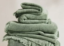 green bath towels folded on stool