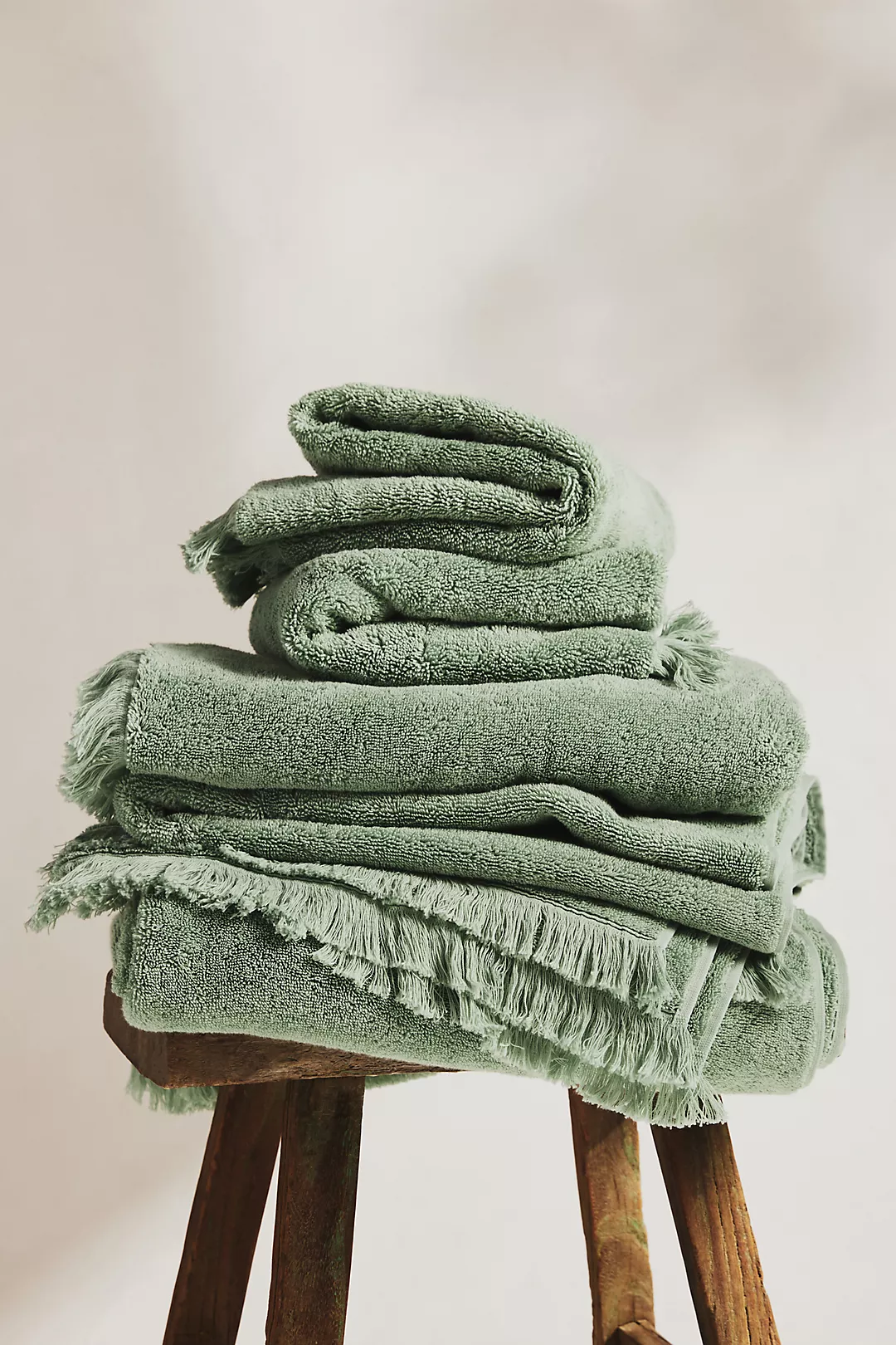 green bath towels folded on stool