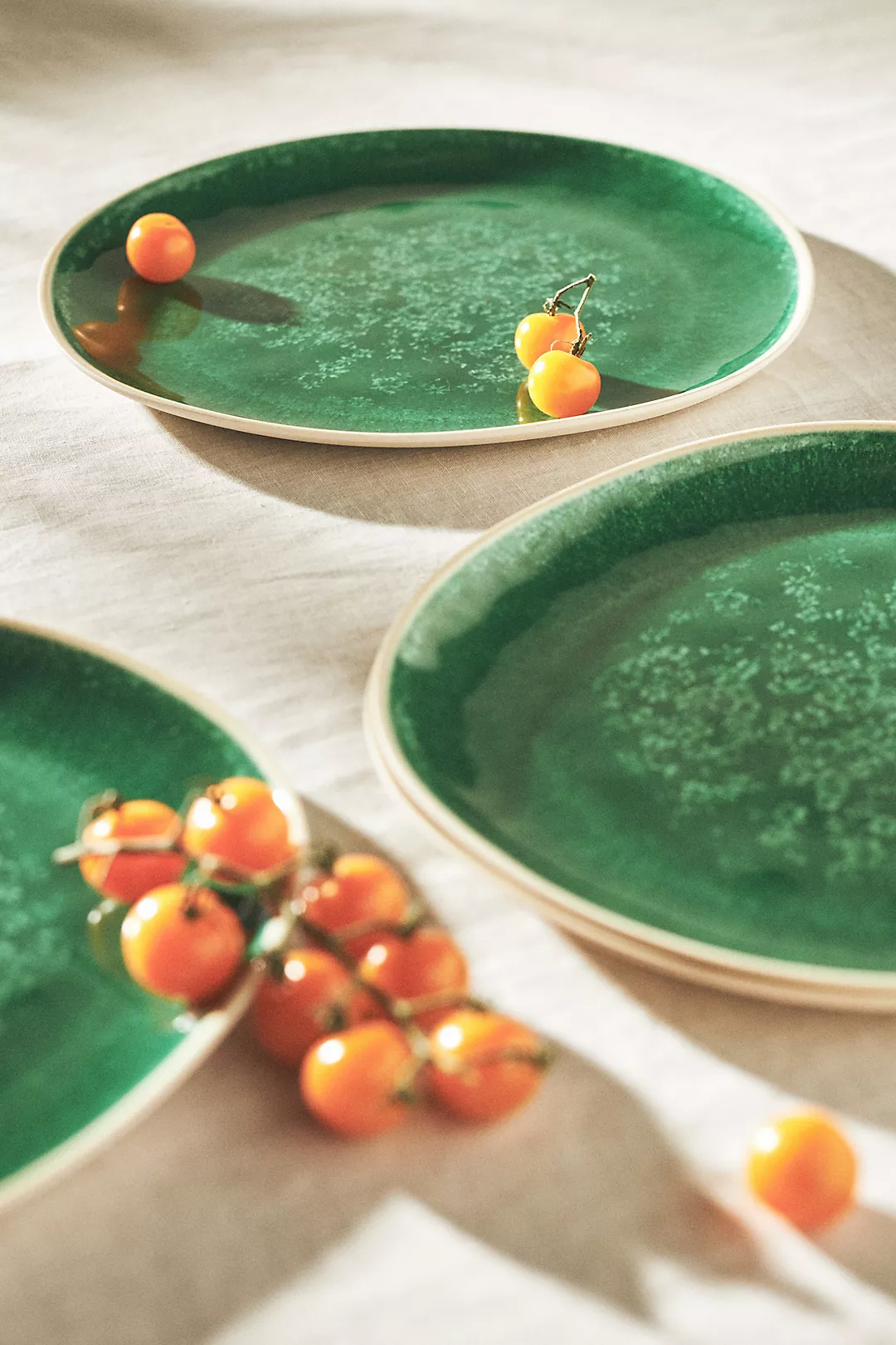 green dinner plates product photo with small orange tomatoes on them