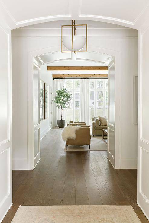 Foyer hallway boasts a trimmed barrel ceiling hold a glass and brass lantern over a wood floor.