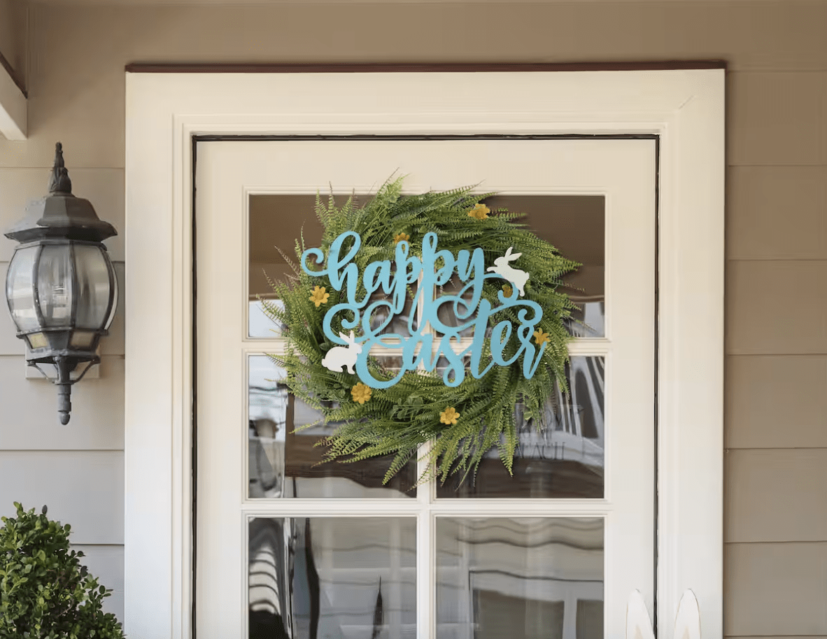metal door hanger happy easter with greenery wreath on white door