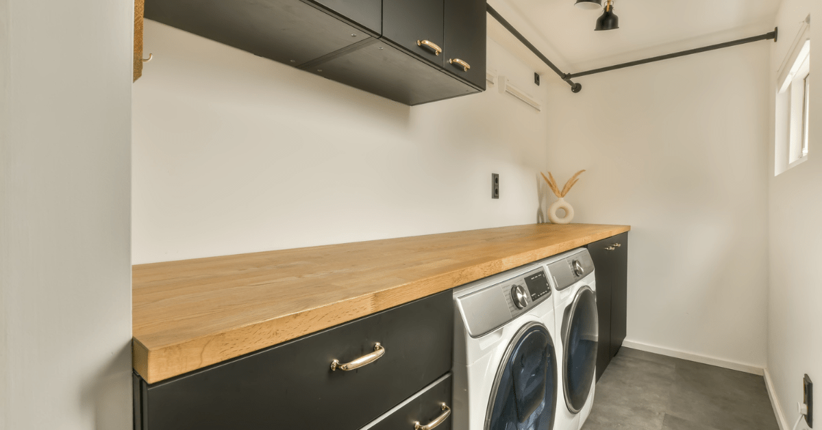 A clutter-free laundry room with black cabinets.
