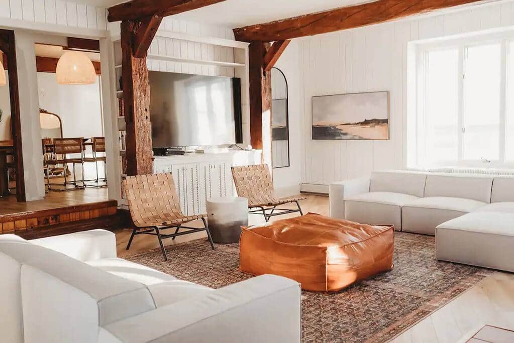Modern beach house living room with wooden ceiling beams.