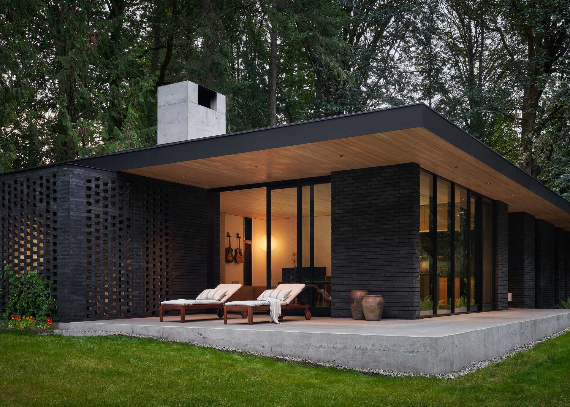 Black brick house with modern design and ceiling-to-floor windows.