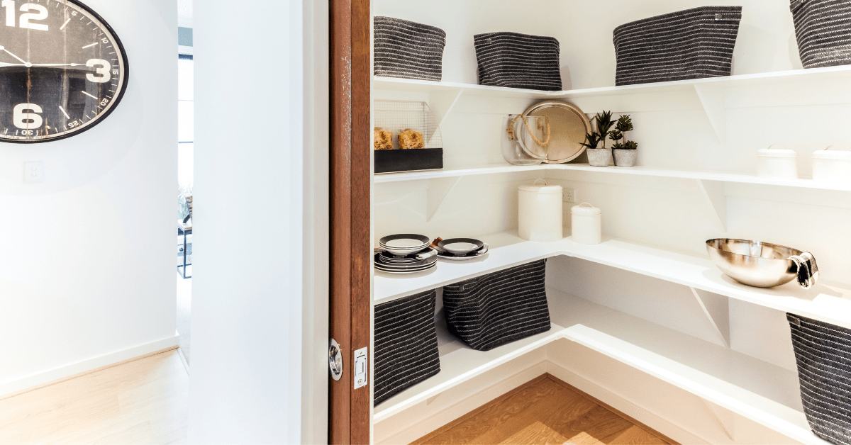 Walk-in pantry with white floating shelves.