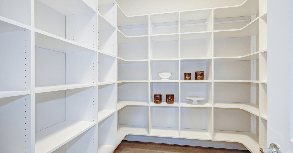 Empty white walk-in pantry with bright lighting.
