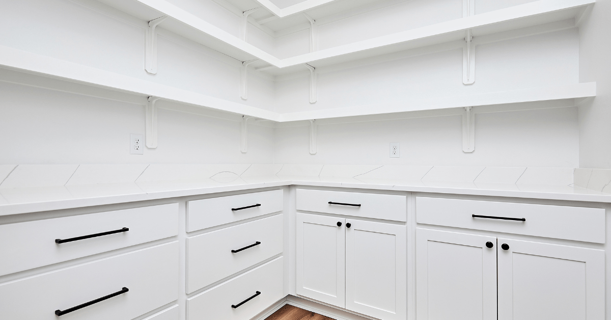 Empty white walk in pantry with drawers for storage.