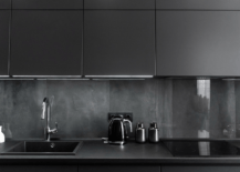 A black themed kitchen with matching black countertops.