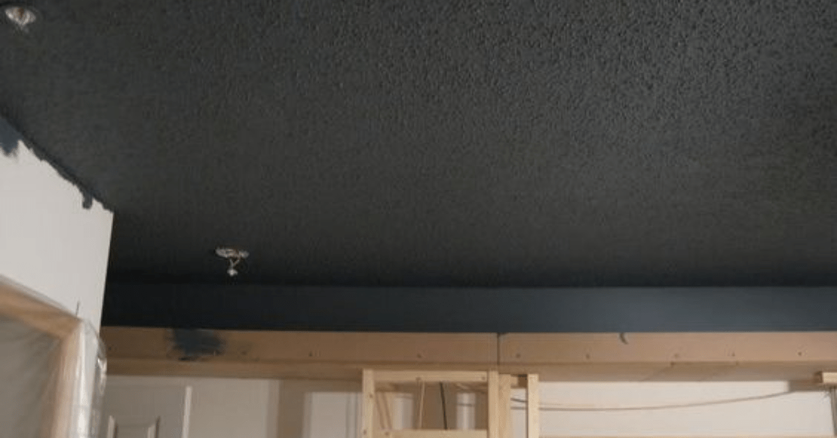 A living room with dark popcorn ceiling.