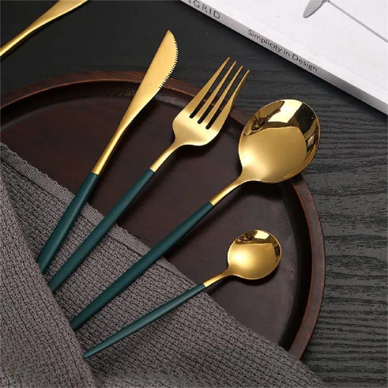 gold and green silverware on wood dish with dish cloth