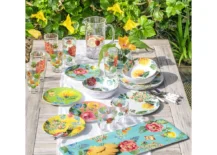 outdoor table set with bright colored floral dishes
