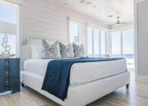 White and blue cottage bedroom features Bungalow 5 Bardot 3 Drawer Dressers placed flanking a white French bed dressed in white and blue bedding complemented with white and blue pillows. The bed sits against a white shiplap wall between windows.